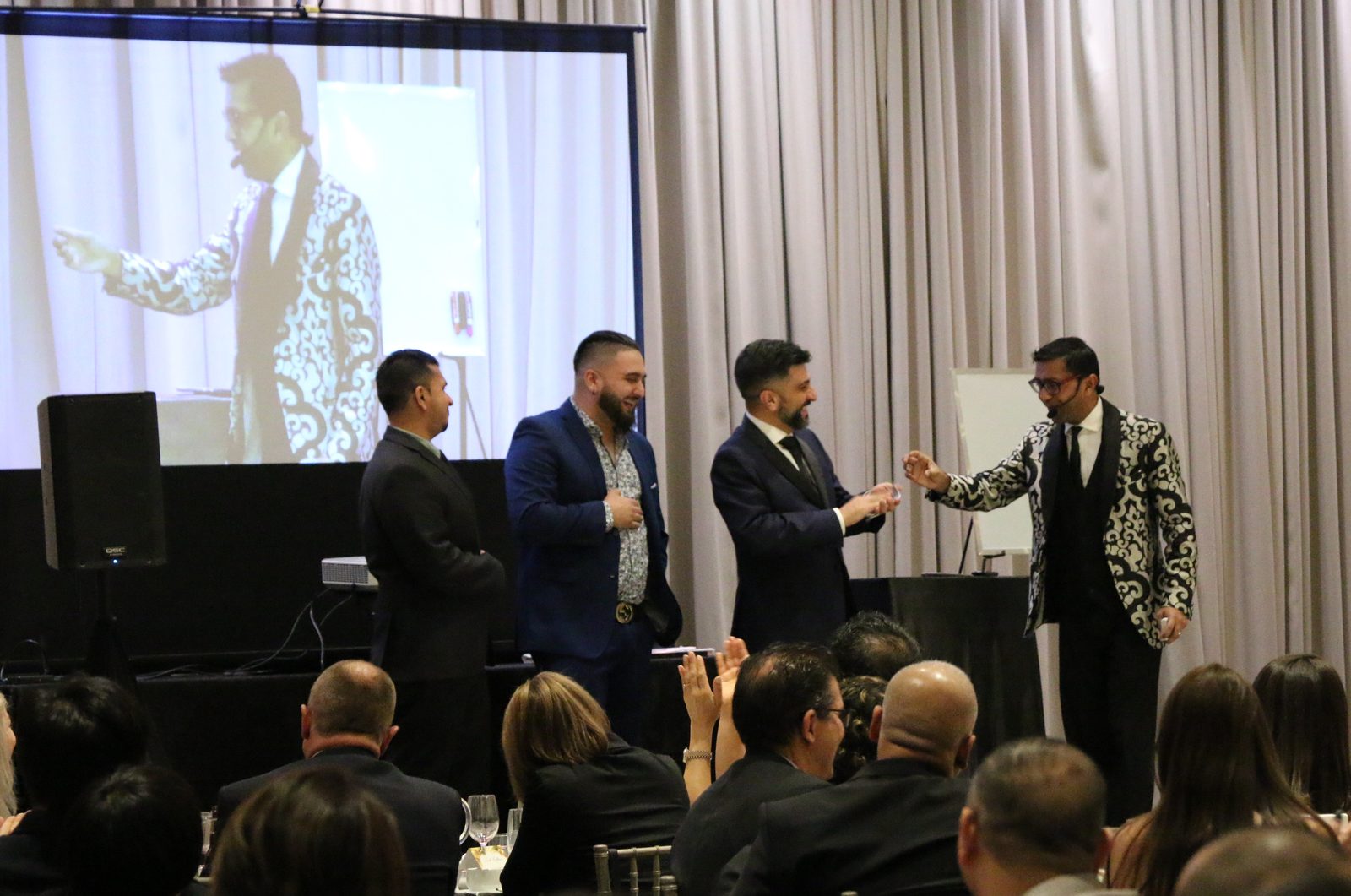 Wij Siva performing on stage for a large corporate audience in Toronto