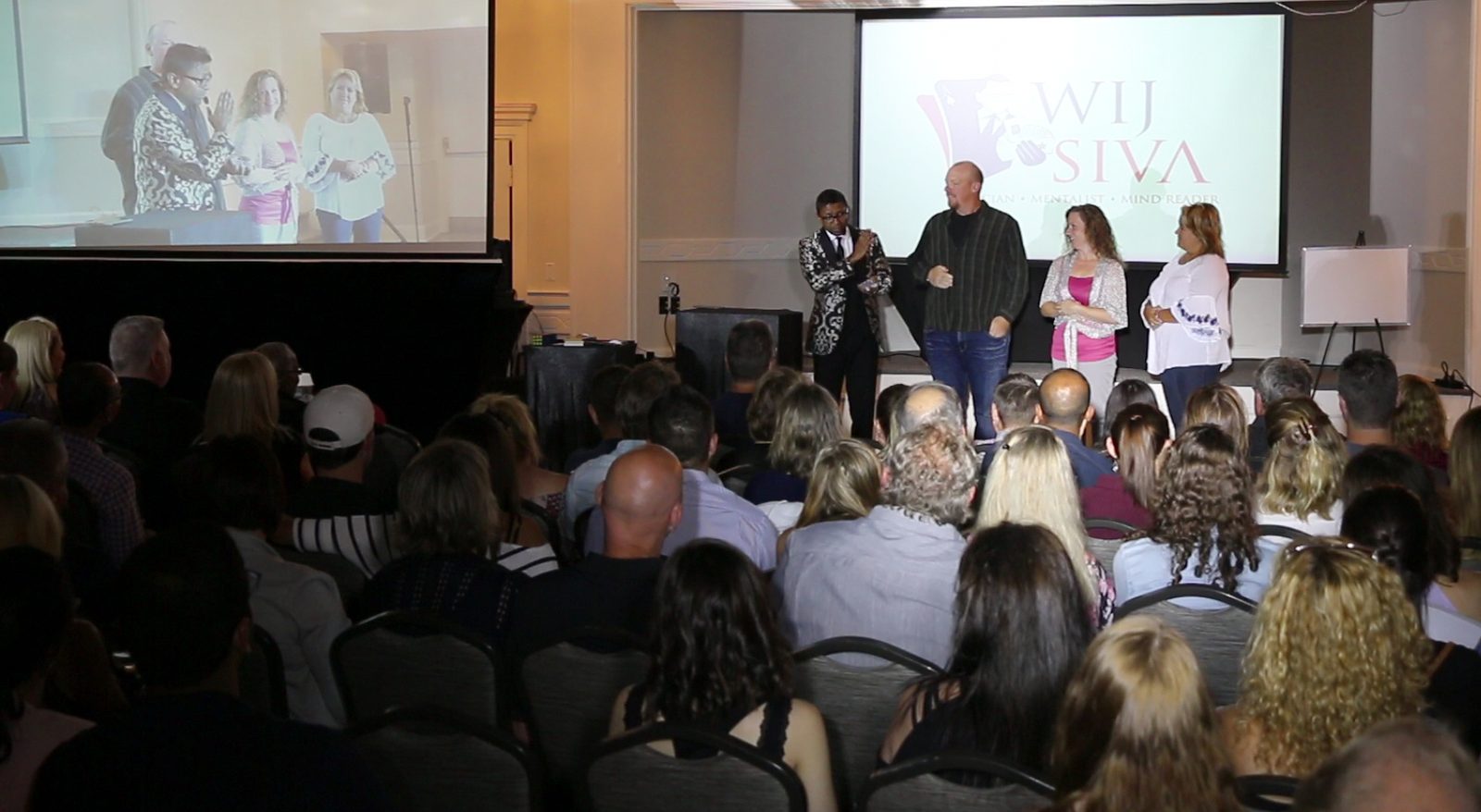 Seated corporate audience watching a magic and mentalism stage show